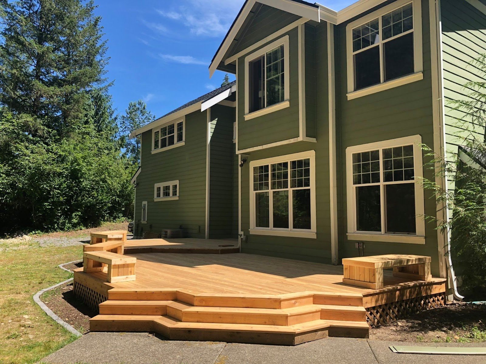 Custom cedar deck with wraparound bench seating and stepped landing